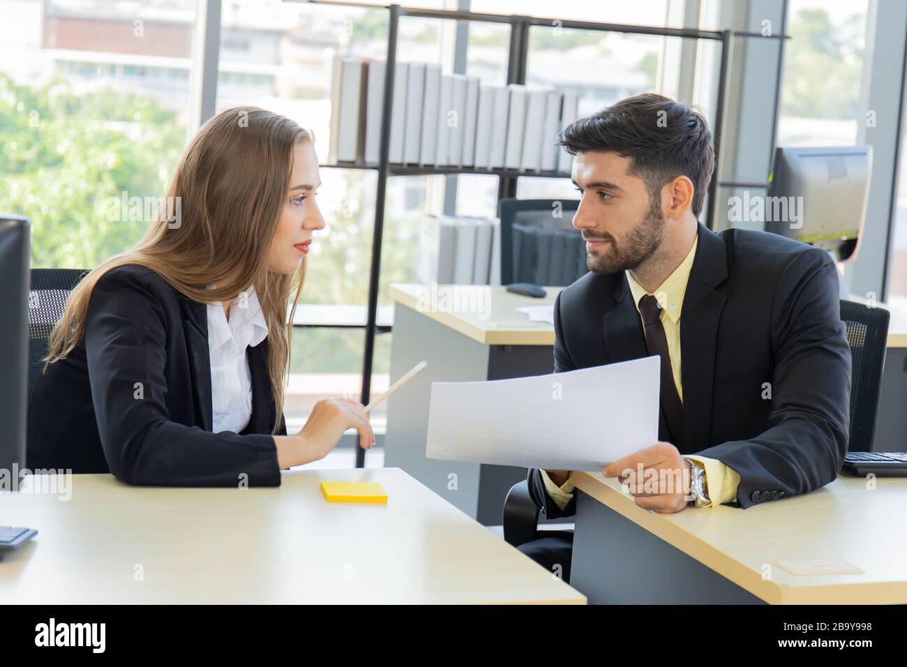 Zwei junge Geschäftsleute, Männer und Frauen Dew, arbeiten mit Glück im Büro Stockfoto