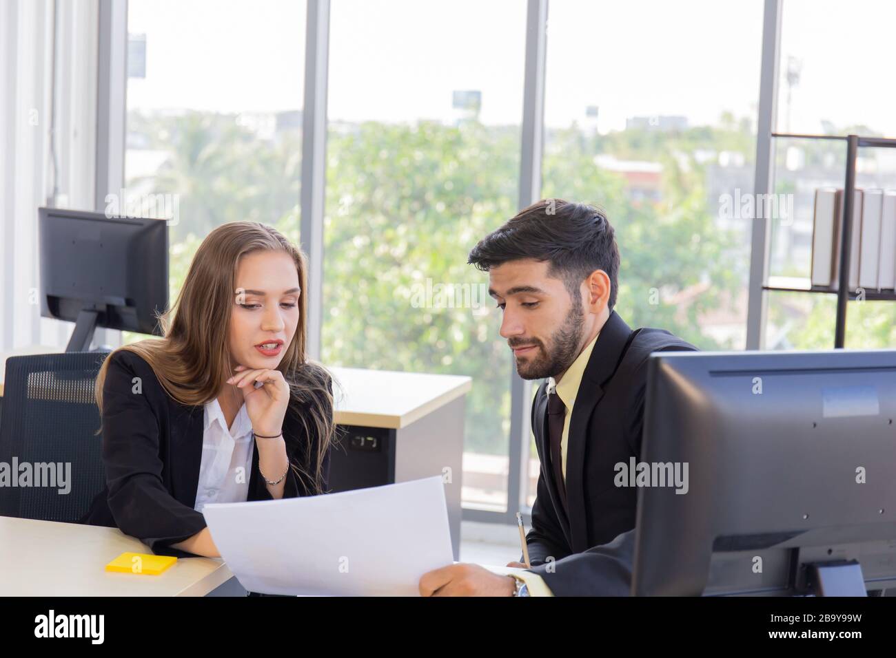 Zwei junge Geschäftsleute, Männer und Frauen Dew, arbeiten mit Glück im Büro Stockfoto