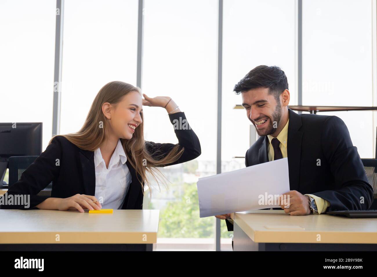 Zwei junge Geschäftsleute, Männer und Frauen, Dew, arbeiten mit Spaß im Büro Stockfoto