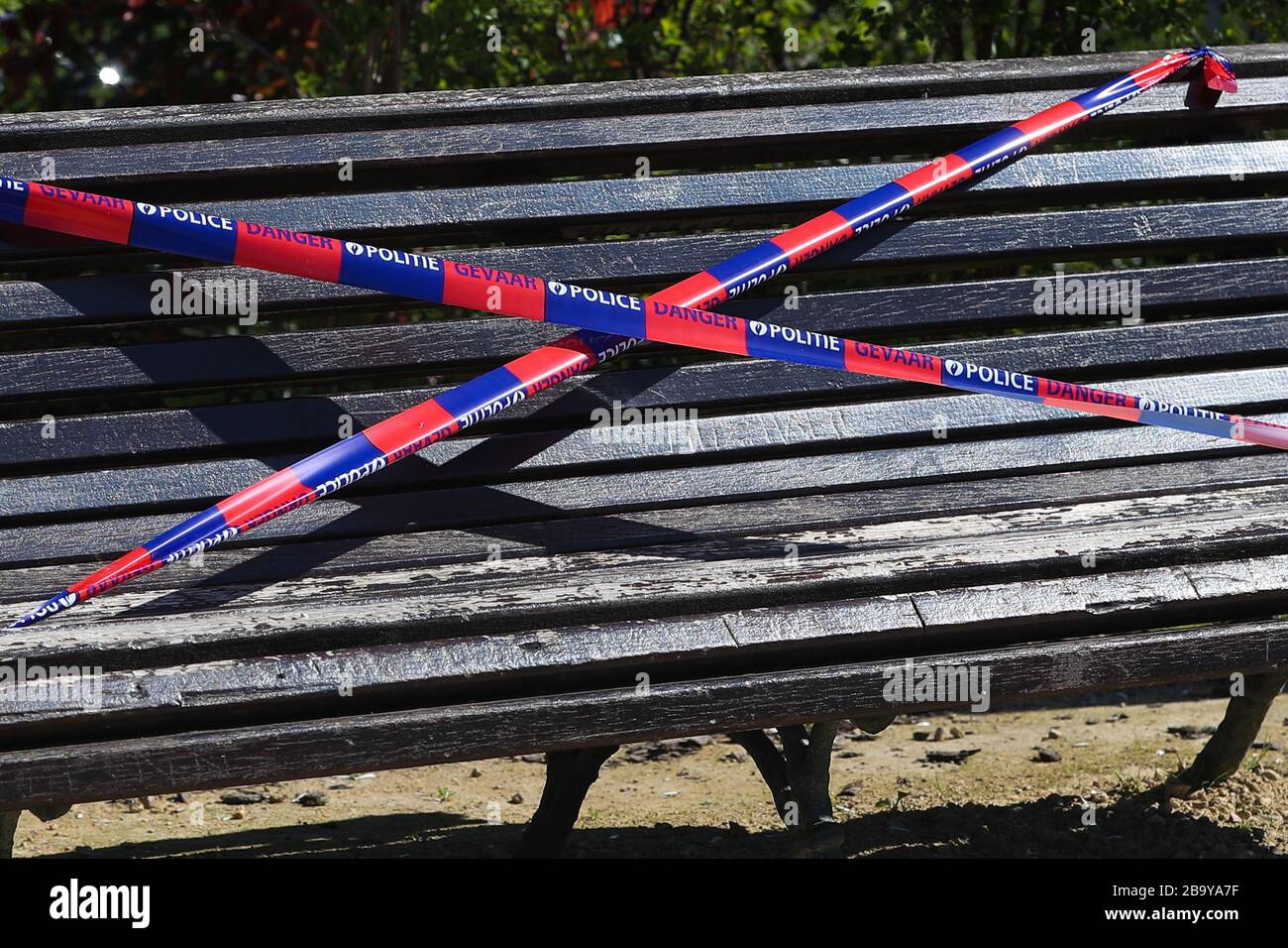 Brüssel, Belgien. März 2020. Eine Bank wird von der Polizei in einem Park in Brüssel, Belgien, am 25. März 2020 mit dem Barrikadenband verbunden gesehen. Bänke in Parks wurden zum Sitzen verboten, um zu verhindern, dass sich Menschen in den Parks sammeln oder zu lange aufhalten. Kredit: Zheng Huansong/Xinhua/Alamy Live News Stockfoto