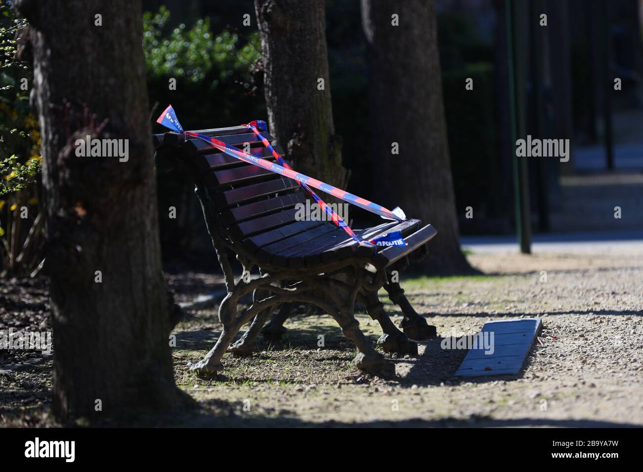 Brüssel, Belgien. März 2020. Eine Bank wird von der Polizei in einem Park in Brüssel, Belgien, am 25. März 2020 mit dem Barrikadenband verbunden gesehen. Bänke in Parks wurden zum Sitzen verboten, um zu verhindern, dass sich Menschen in den Parks sammeln oder zu lange aufhalten. Kredit: Zheng Huansong/Xinhua/Alamy Live News Stockfoto