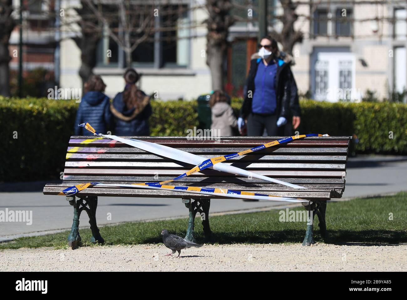 Brüssel, Belgien. März 2020. Eine Bank wird von der Polizei in einem Park in Brüssel, Belgien, am 25. März 2020 mit dem Barrikadenband verbunden gesehen. Bänke in Parks wurden zum Sitzen verboten, um zu verhindern, dass sich Menschen in den Parks sammeln oder zu lange aufhalten. Kredit: Zheng Huansong/Xinhua/Alamy Live News Stockfoto