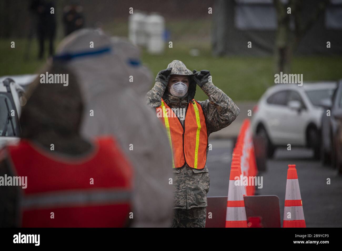 Holmdel, Vereinigte Staaten. März 2020. Ein Luftwaffenflieger der New Jersey Air Guard aus dem 108. Flügel passt ihre Haube an und kontrolliert den Verkehr auf einer COVID-19-Community-basierten Testseite im PNC Bank Arts Center in Holmdel, N.J.am 23. März 2020. Der in Partnerschaft mit der Federal Emergency Management Agency eingerichtete Teststandort ist mit dem Gesundheitsministerium von New Jersey, der Staatspolizei von New Jersey und der Nationalgarde von New Jersey besetzt. Foto von Master Sgt. Matt Hecht/USA Air National Guard/UPI Credit: UPI/Alamy Live News Stockfoto