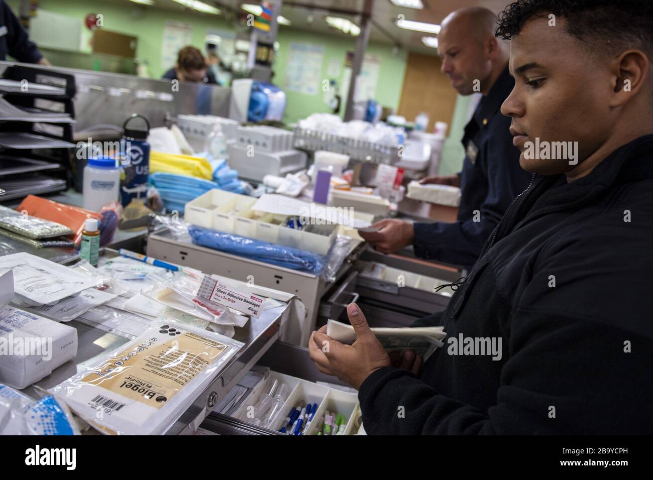 Los Angeles, Kalifornien, USA. März 2020. Hospitalman Jeremiah Lewis aus San Antonio organisiert am 24. März 2020 medizinische Versorgung an Bord des Militärsealift Command Hospitalschiff USNS Mercy (T-AH 19). Mercy wird zur Unterstützung der COVID-19-Reaktionsbemühungen des Landes eingesetzt und dient als Überweisungskrankenhaus für nicht-COVID-19-Patienten, die derzeit in Krankenhäusern am Land eingeliefert werden. So können Landkrankenhäuser ihre Bemühungen auf COVID-19-Fälle konzentrieren. Eine der Missionen des Verteidigungsministeriums ist die Verteidigungsunterstützung von Zivilbehörden. DoD unterstützt die Federal Emergency Management AG Stockfoto