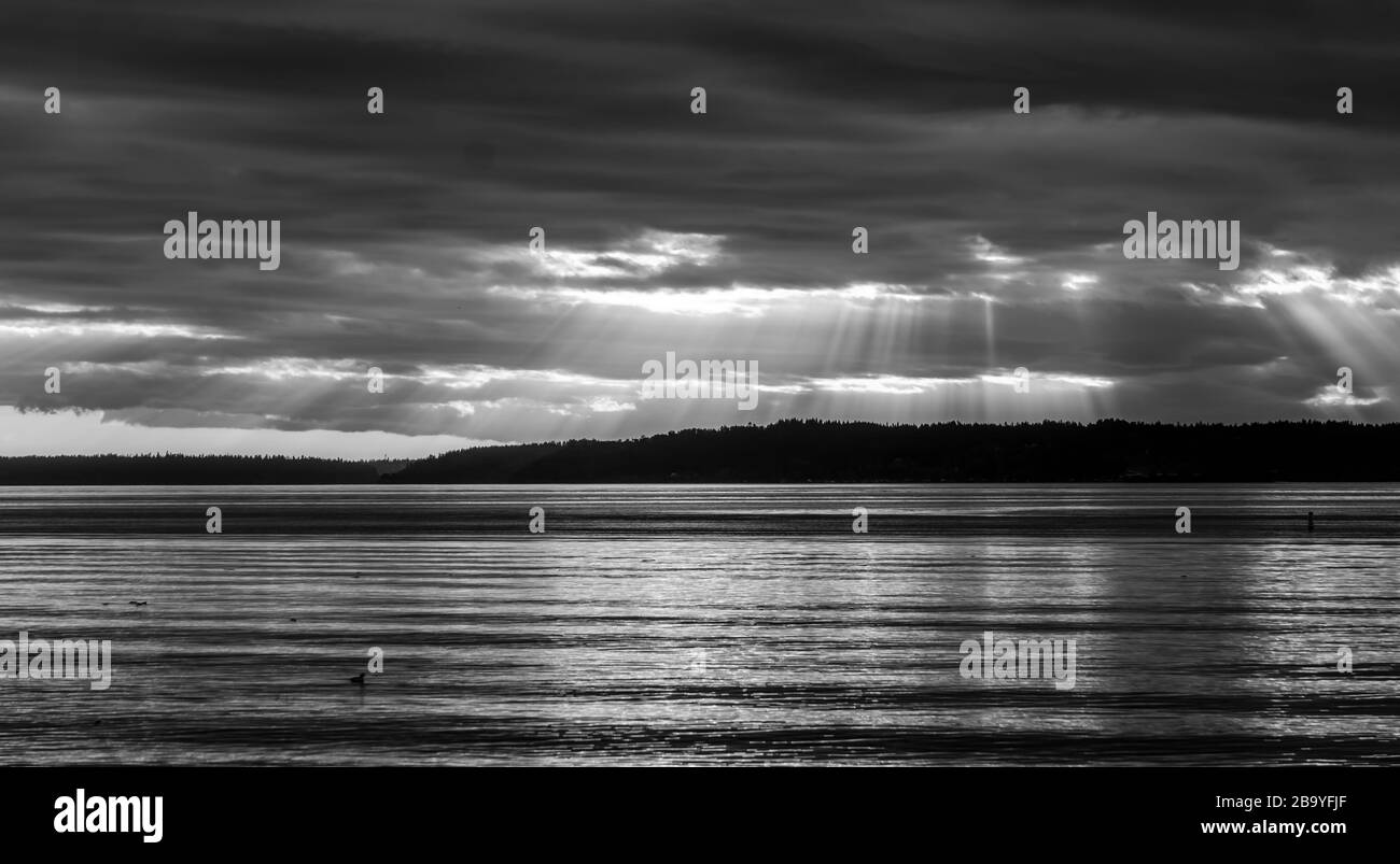 Sonnenstrahlen durchbrechen dunkle Wolken über dem Puget Sound im Staat Washington. Stockfoto
