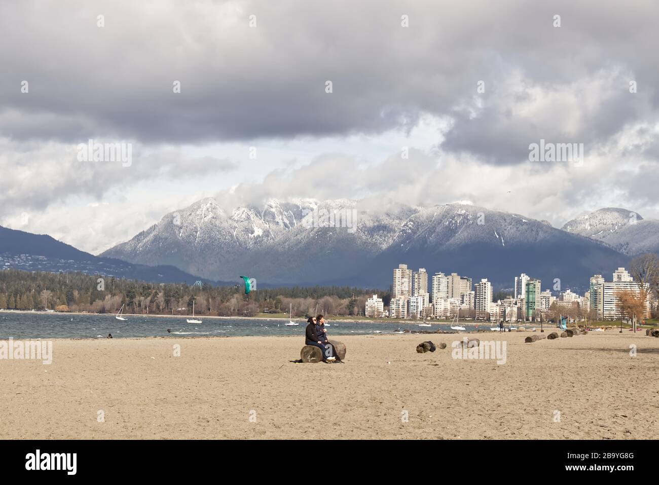 Vancouver, Kanada - Februar 29,2020: Am Kitsilano Beach sitzen die Leute während des sonnigen Tages in Vancouver Stockfoto