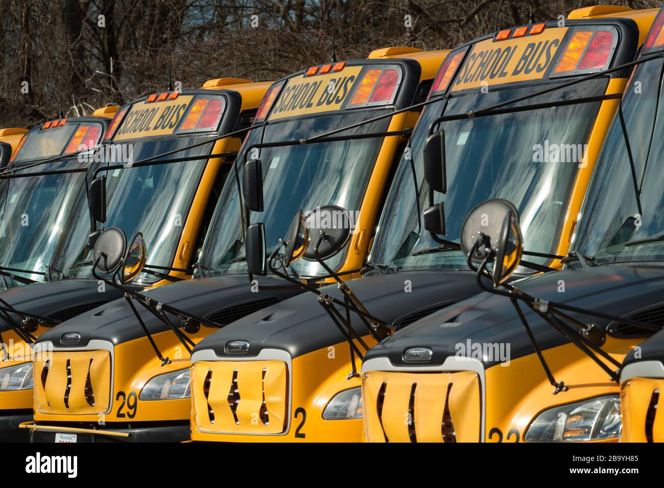 Coronavirus, Idle School Buses, Lexington, Massachusetts, USA. März 2020. Mehr als 50 leerlaufende Schulbusse an einem Wochentag am Nachmittag. Lexington, Bevölkerung über 30.000, in der Nähe von Boston, MA, hat die 11 öffentlichen Schulen der Stadt aufgrund des Coronavirus geschlossen, das die 7.000 Schüler des Schulbezirks betrifft. Stockfoto