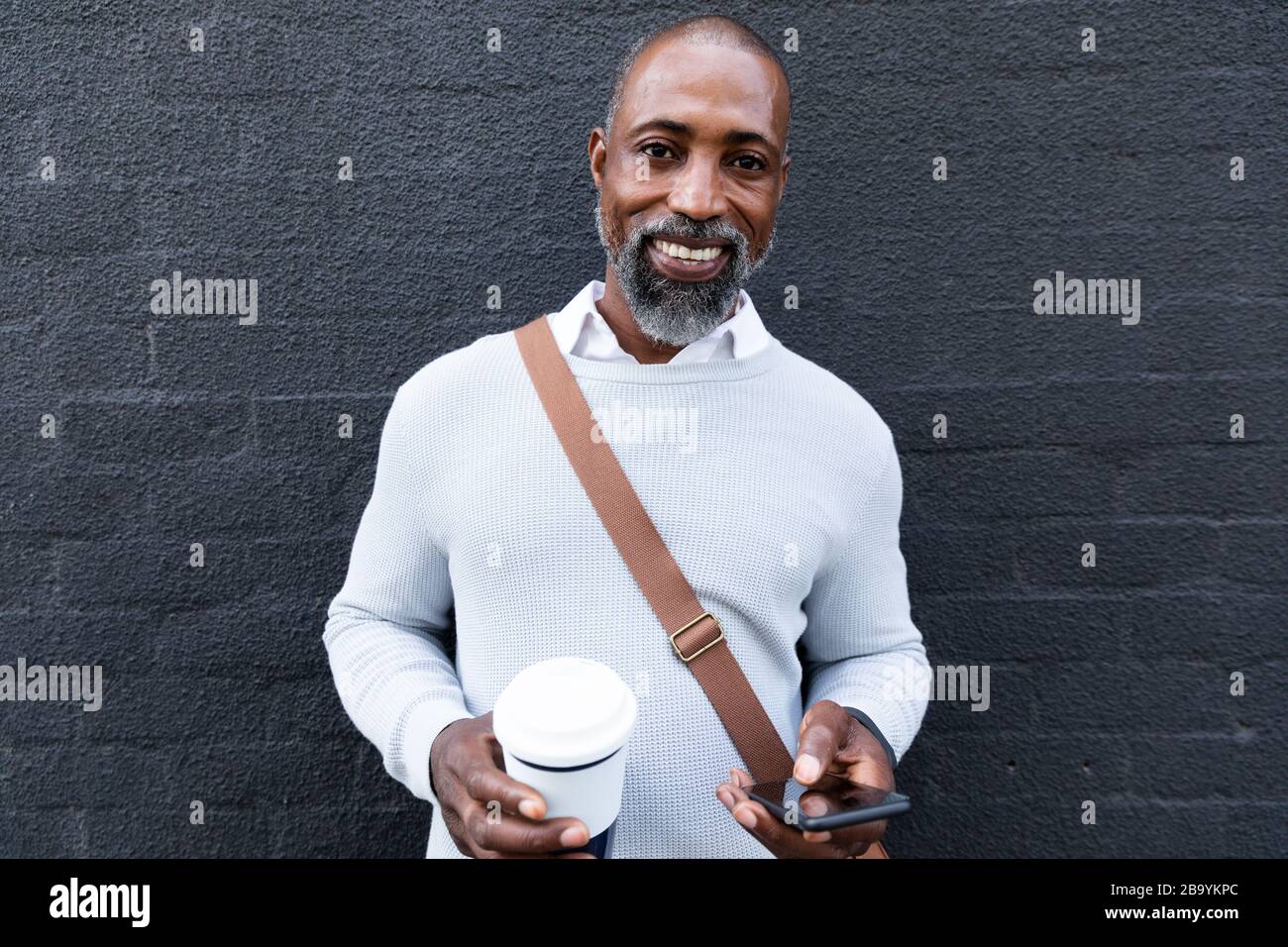 Afroamerikanischer Mann mit seinem Telefon auf der Straße Stockfoto