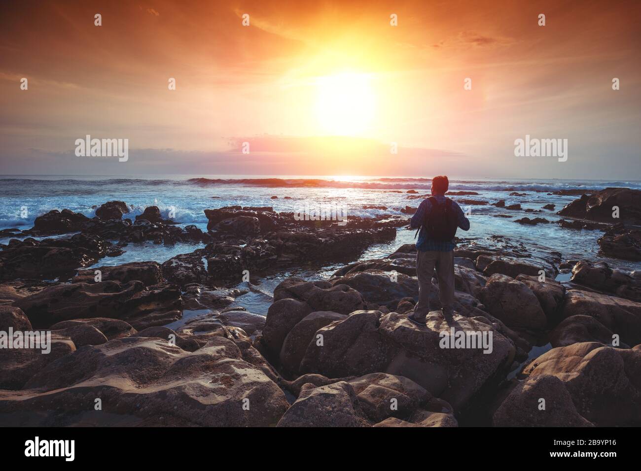 Am Abend seekapern. Die felsige Küste. Silhouette eines Mannes am Strand, der den magischen Sonnenuntergang beobachtet Stockfoto