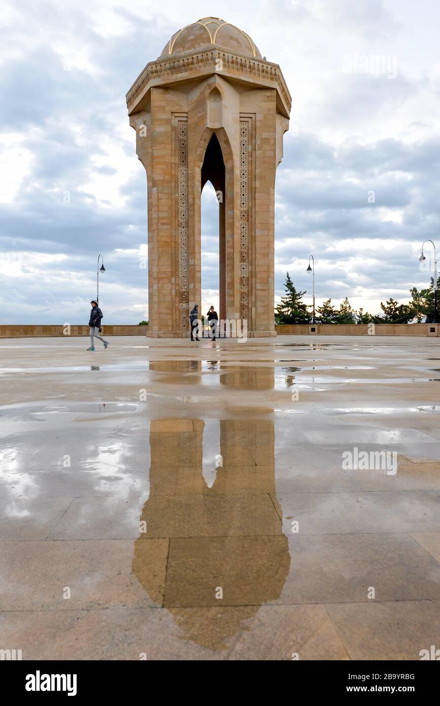 Shahildar-Denkmal, das auf dem nassen Boden reflektiert wird, auch bekannt als Eternal Flame Monument, das sich in der Martyrs Lane in Baku, Aserbaidschan befindet. Vertikales Foto Stockfoto