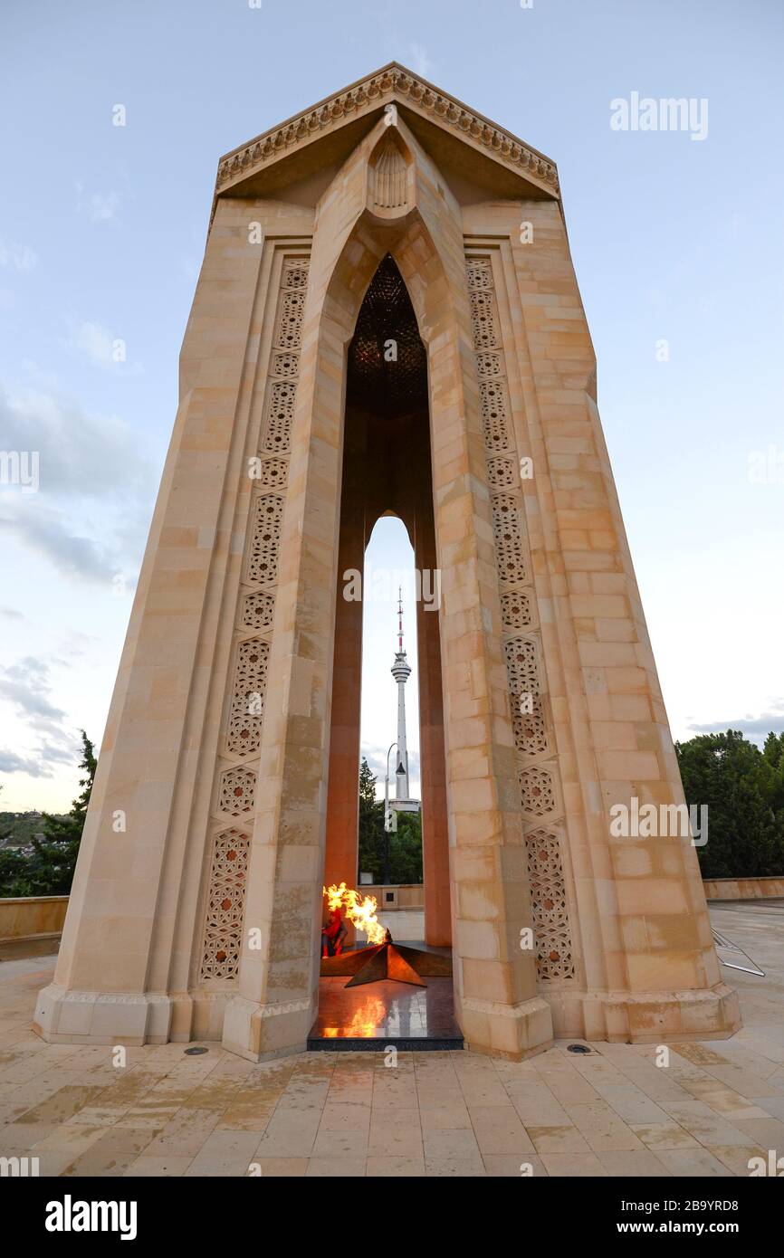 Shahildar Monument, auch bekannt als Eternal Flame Monument (Feuer sichtbar), das sich in der Martyrs Lane, Baku, Aserbaidschan befindet. Fernsehturm sichtbar. Stockfoto