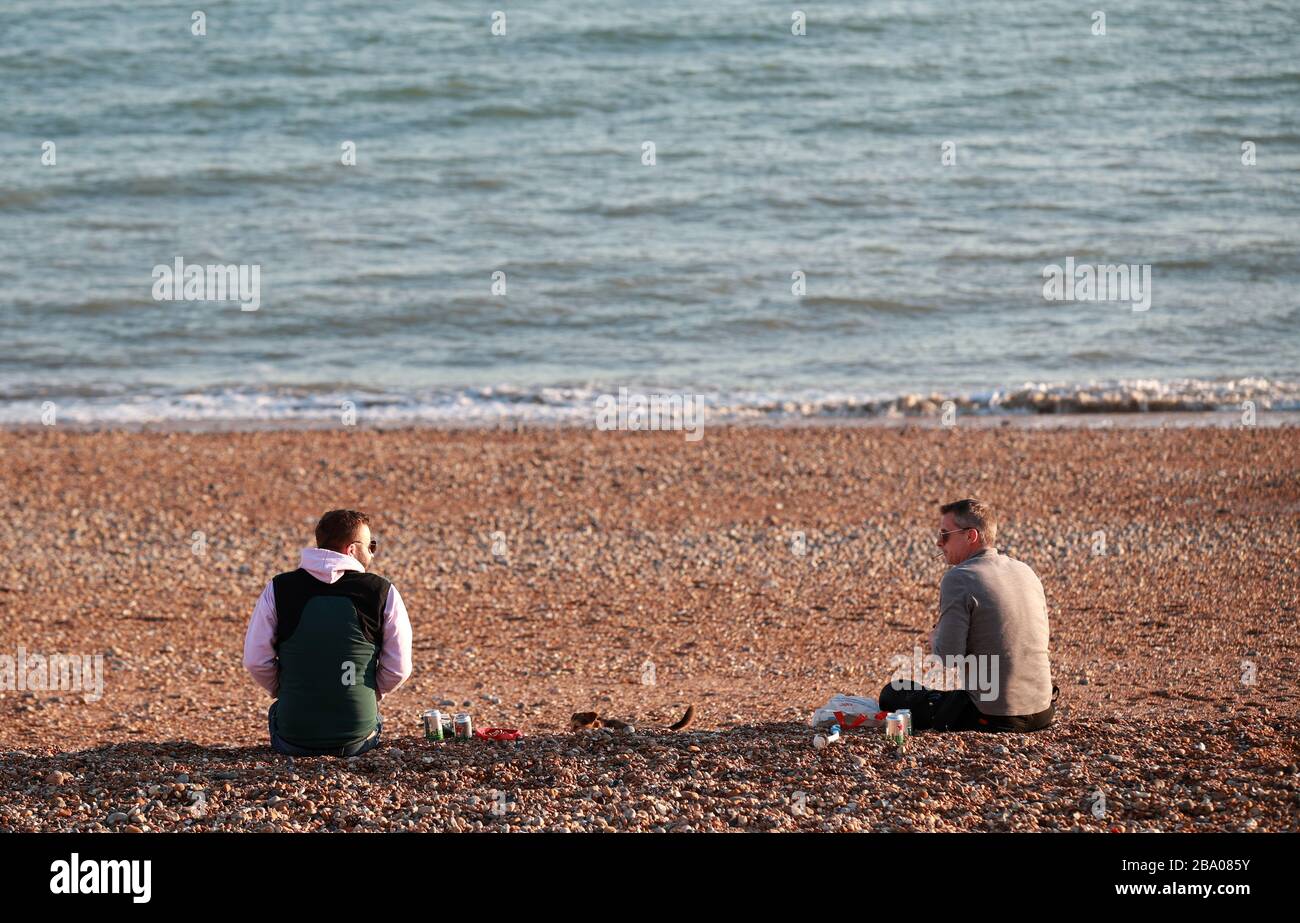 Menschen, die soziale Distanzierung am Brighton Beach beobachten, nachdem Premierminister Boris Johnson die Entscheidung getroffen hatte, Großbritannien in eine Sperrstelle zu setzen, um die Ausbreitung des Coronavirus einzudämmen. Stockfoto