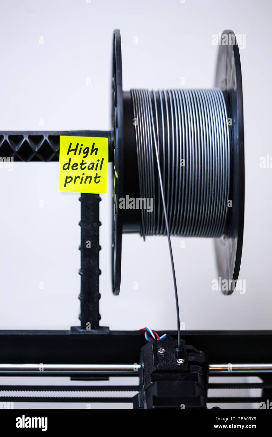Ein 3D-Druckerkopf mit geladenem Filament und einer Spule aus PLA-Material für detailreiche 3D-Drucke. Stockfoto