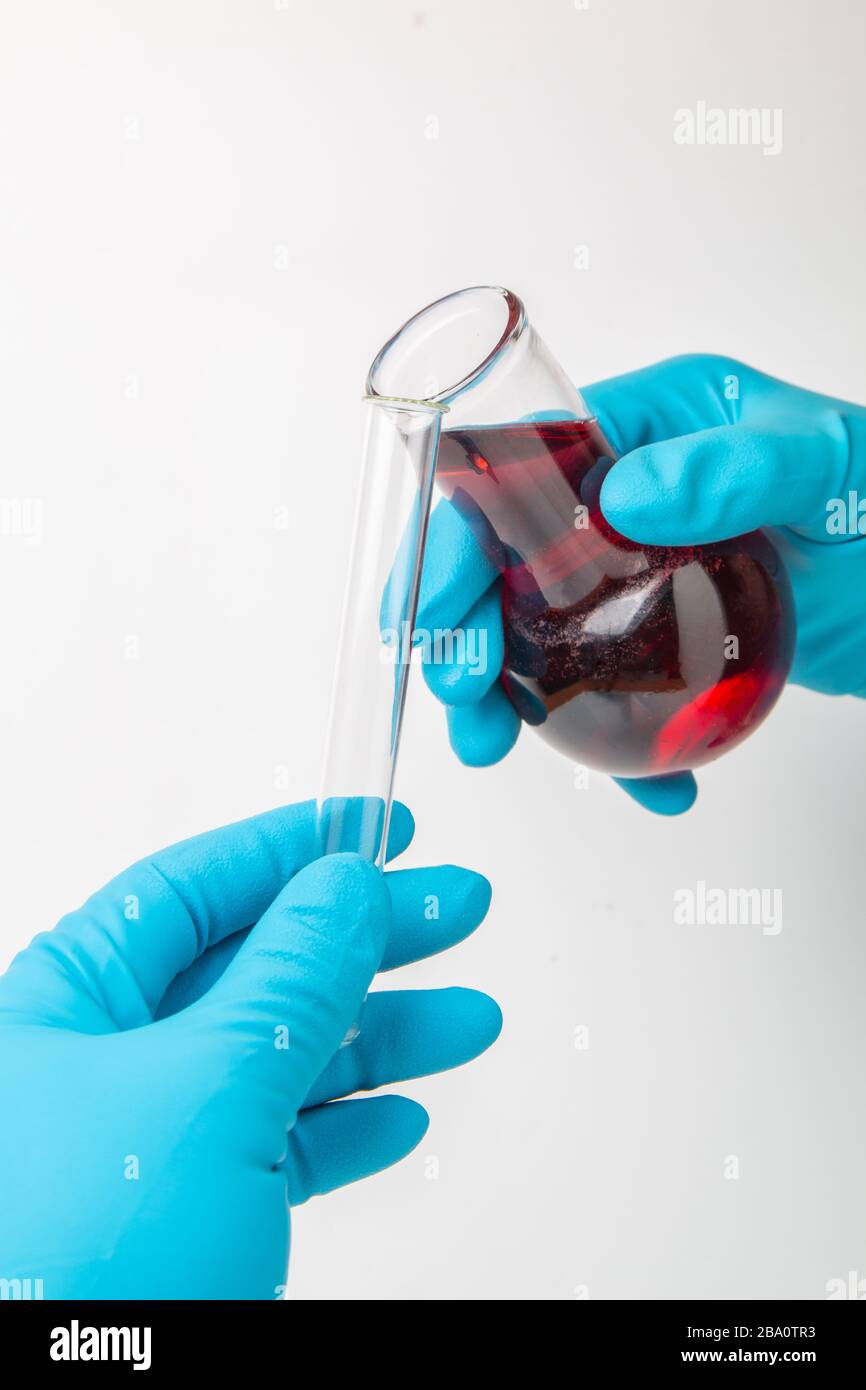 Medizinisches Forschungslabor. Transfusion einer chemischen Flüssigkeit aus einem Kolben in ein Reagenzglas Stockfoto