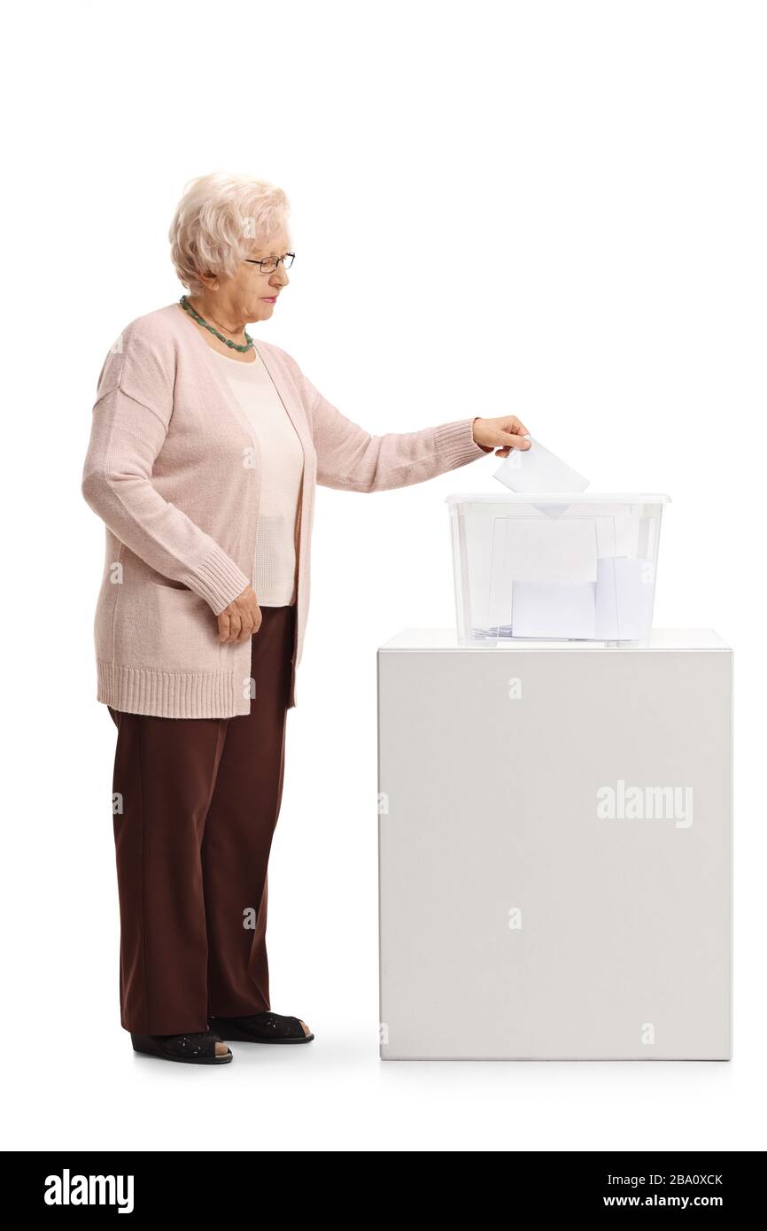 Schuss einer älteren Frau, die eine Stimme in einer Wahlurne abgegeben hat, die auf weißem Hintergrund isoliert ist Stockfoto