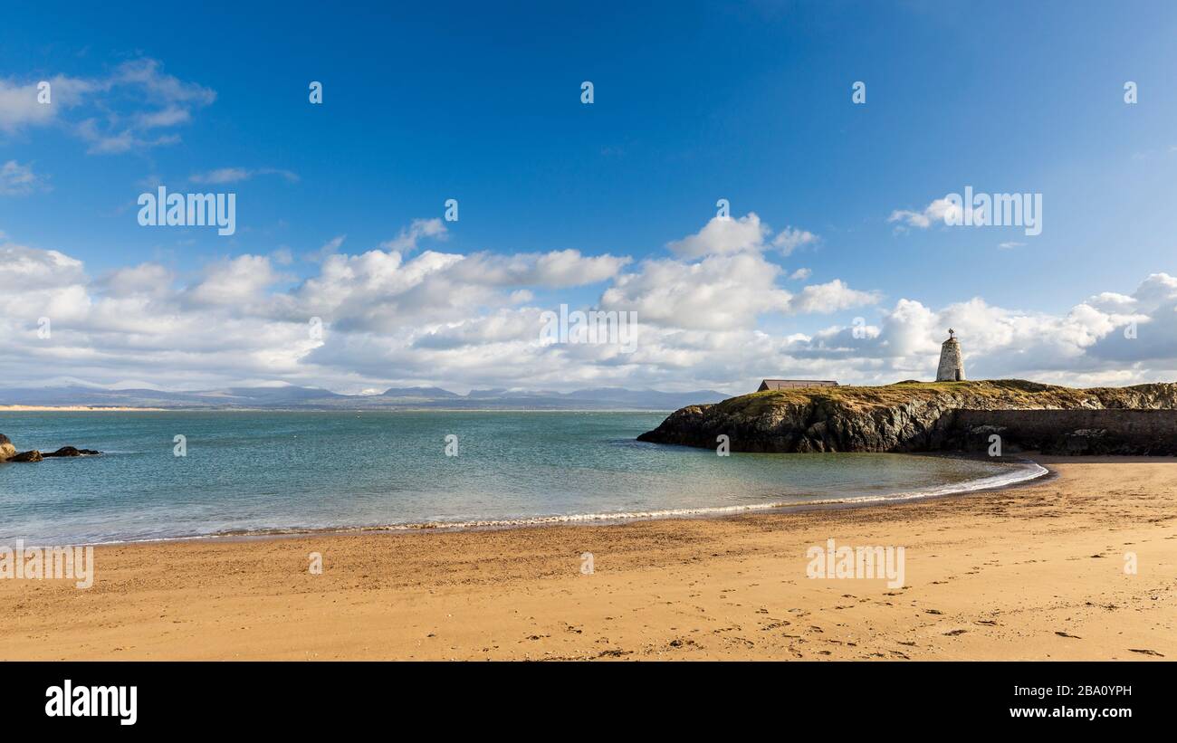 Der Leuchtturm von TWR Bach auf der Insel Llanddwyn mit Snowdonia im Hintergrund, Anglesey Stockfoto