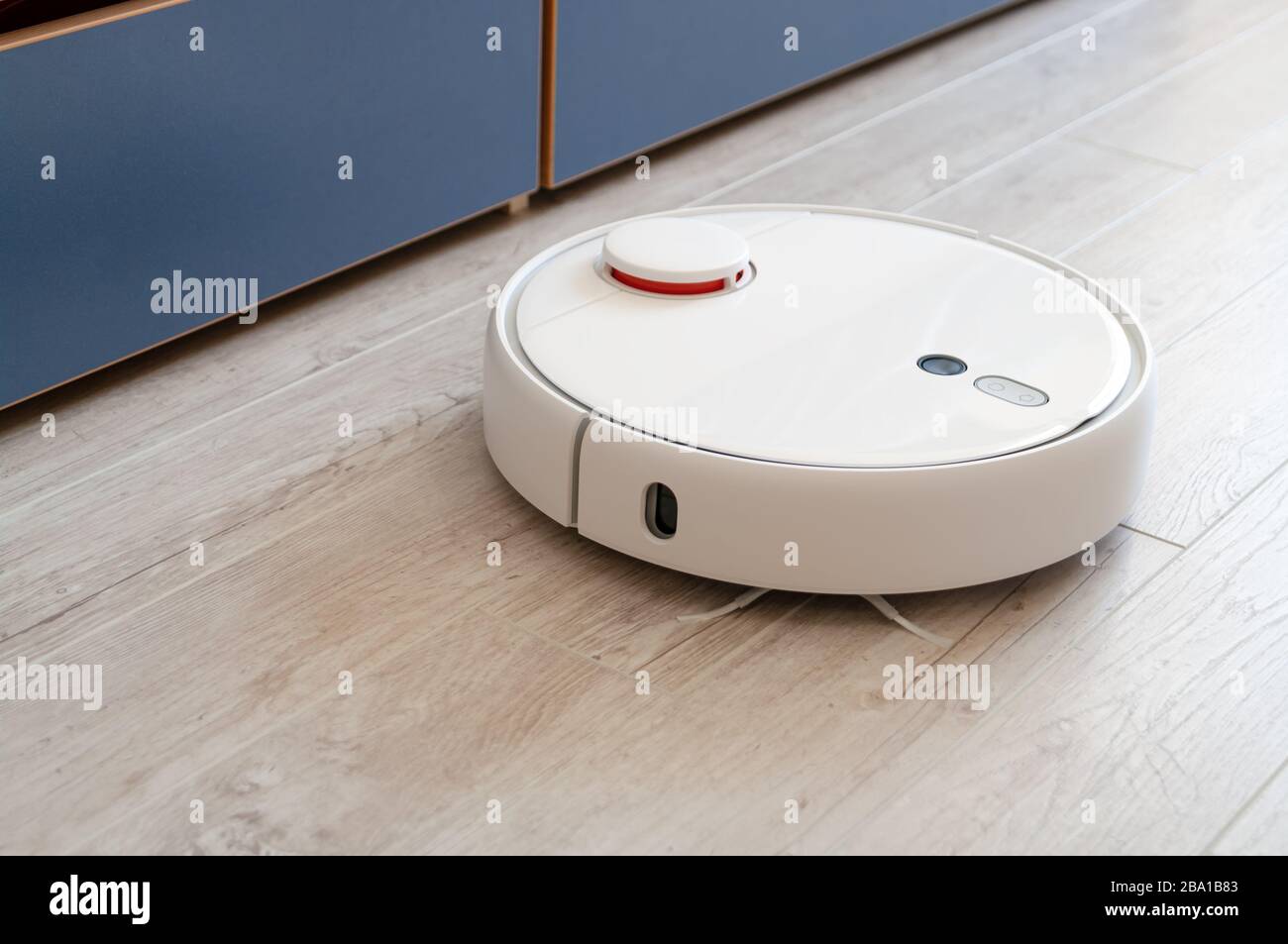 Roboter-Staubsauger auf Laminatboden mit intelligenter Reinigungstechnologie Stockfoto