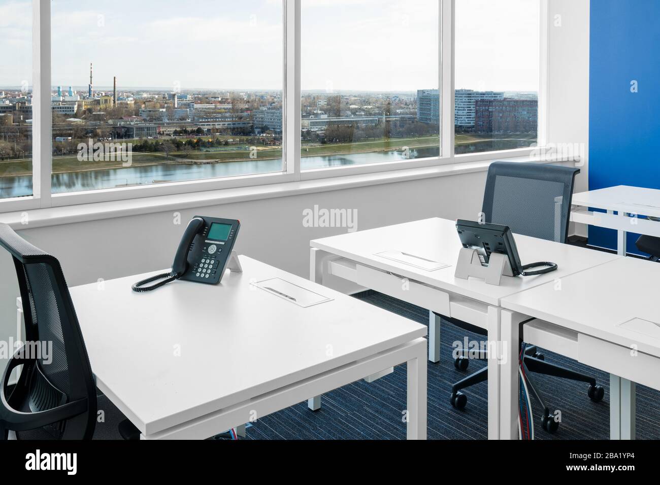 Weißer Schreibtisch mit Telefon im offenen Büro Stockfoto