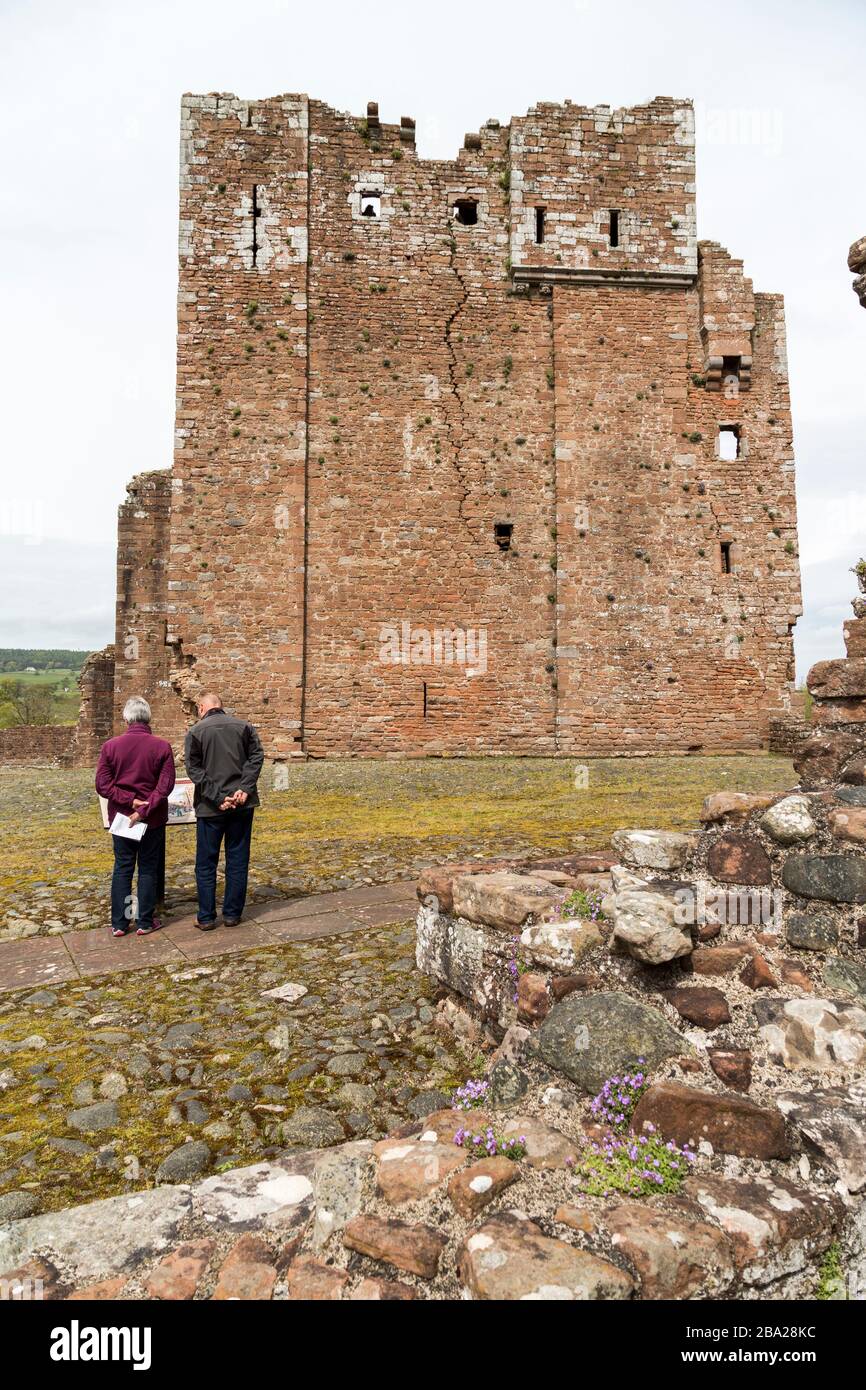 Lesen eines Informationszeichens über den Bergfried in Brougham Castle Ruin, Cumbria, England, Großbritannien Stockfoto