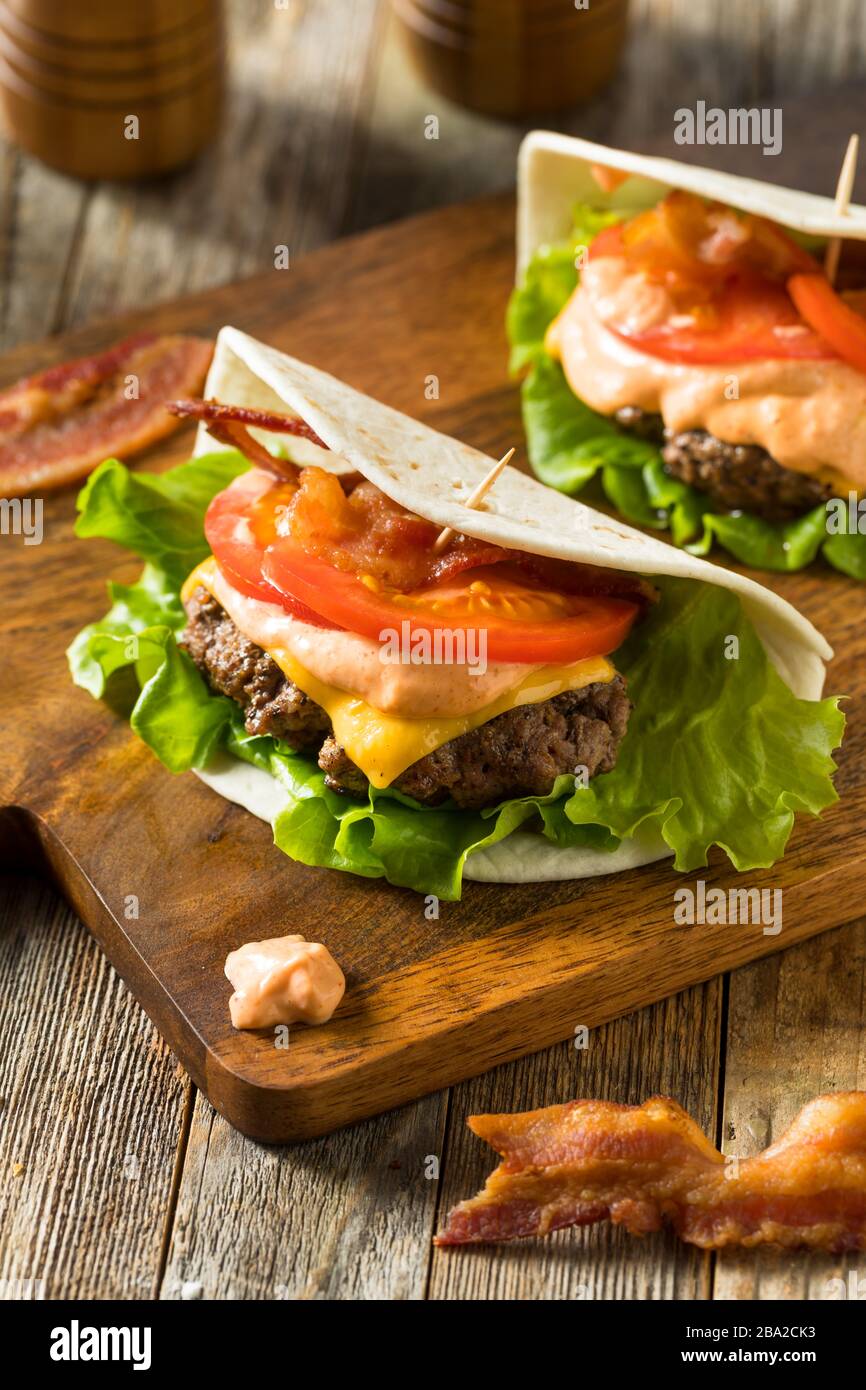 Hausgemachter Cheeseburger Taco in einer Tortilla mit Salat und Tomato Stockfoto
