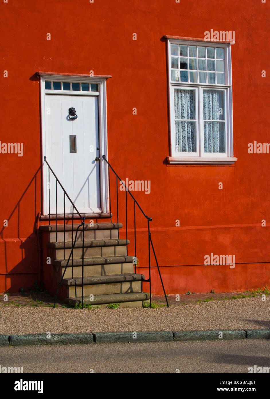 Roter Hauseingang mit weißer Tür und Fenster Stockfoto