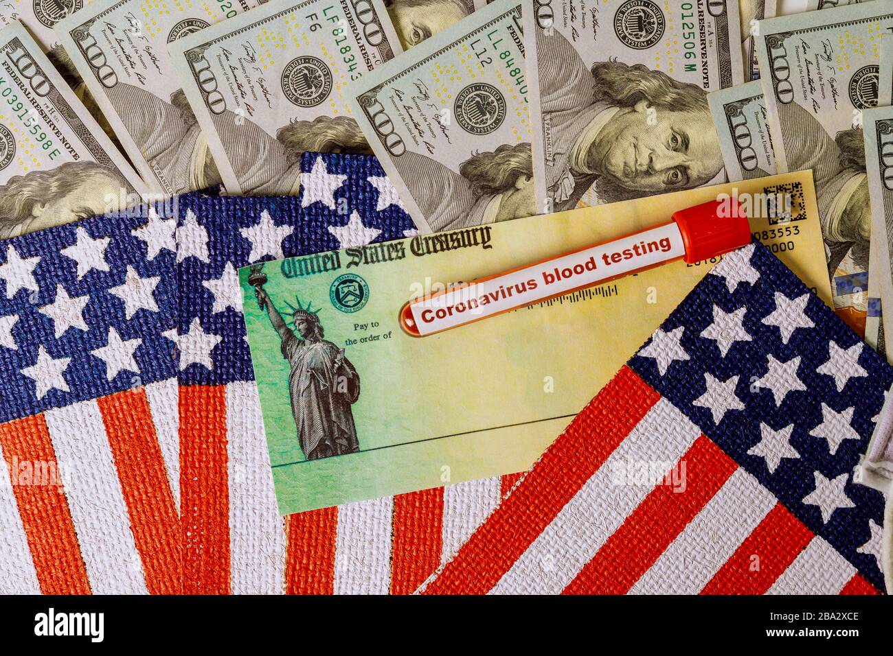 Global Pandemie Covid 19 lockdown Coronavirus Konjunkturpaket Entlastungskontrollen von Regierung 100 Dollar Rechnungen Währung auf amerikanischer Flagge Stockfoto