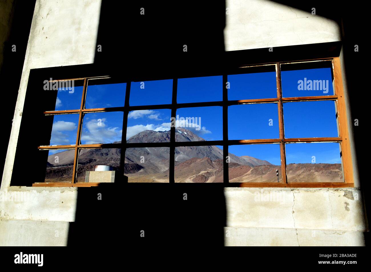 Schöner Blick auf den Vulkan Socompa durch ein Fenster des Bahnschuppens am Bahnhof Socompa des "Zuges zu den Wolken", Provinz Salta, Argent Stockfoto