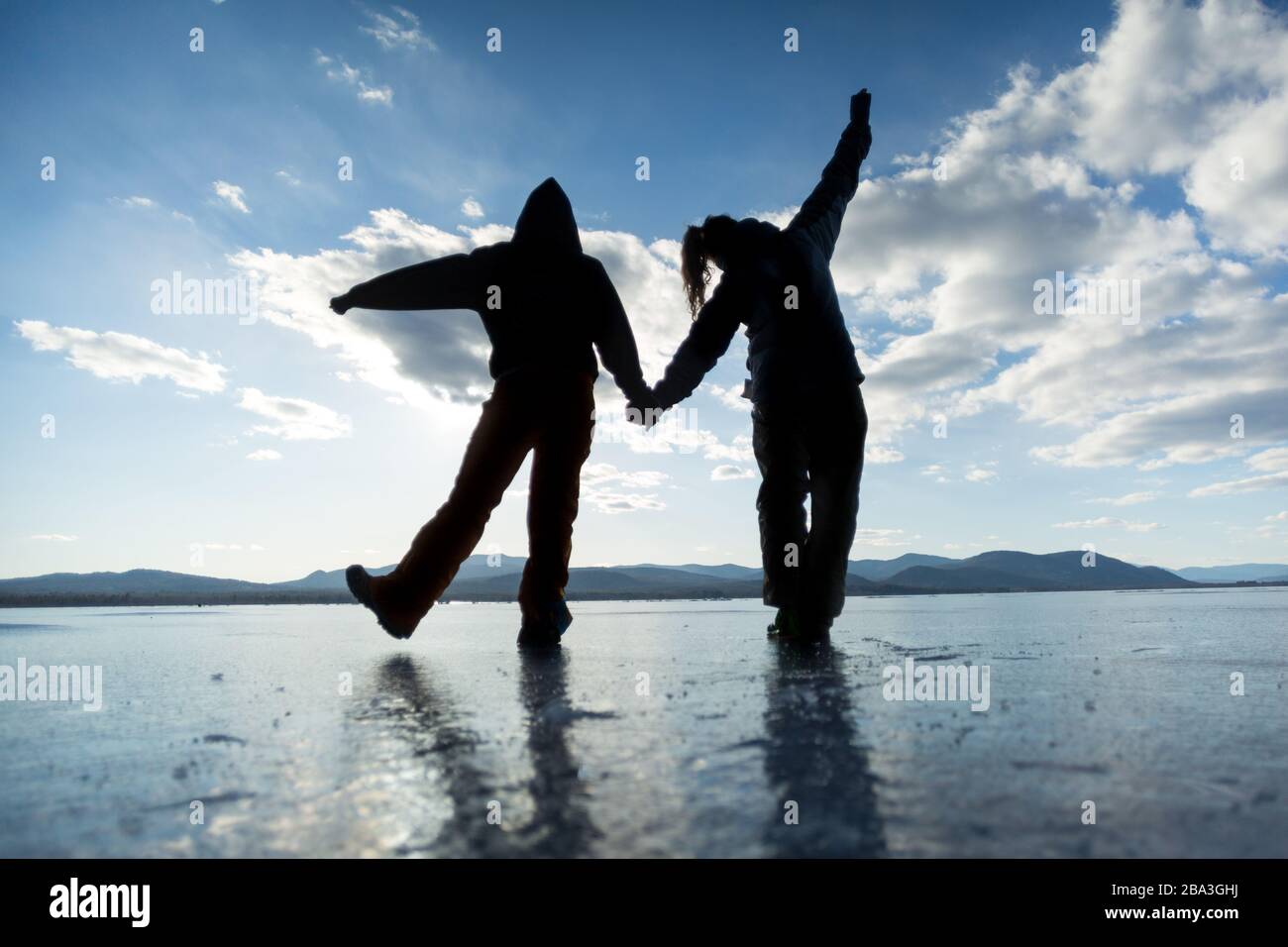 Freunde halten die Hände auf einem gefrorenen Teich. Stockfoto