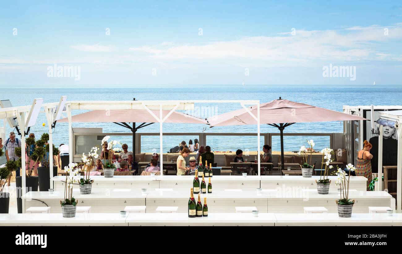 Inneneinrichtung der Bondi Beach Bar am Oostende Beach an einem Sommernachmittag mit Kunden und Touristen. Stockfoto