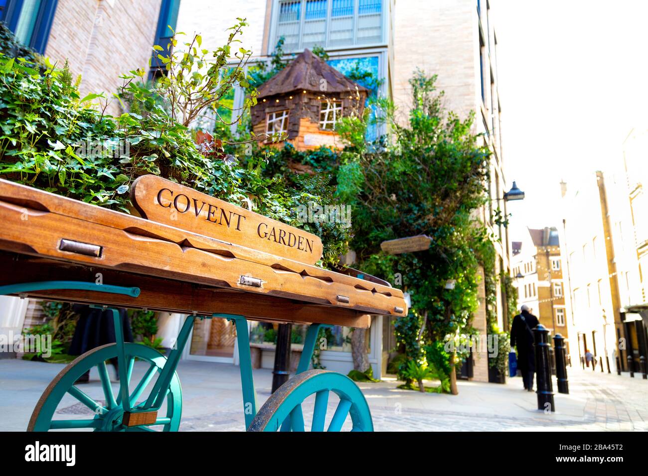 Marktwagen voller Pflanzen und Covent Garden geschrieben darauf und Dominique Ansel Treehouse Patisserie und Café im Hintergrund, London, Großbritannien Stockfoto