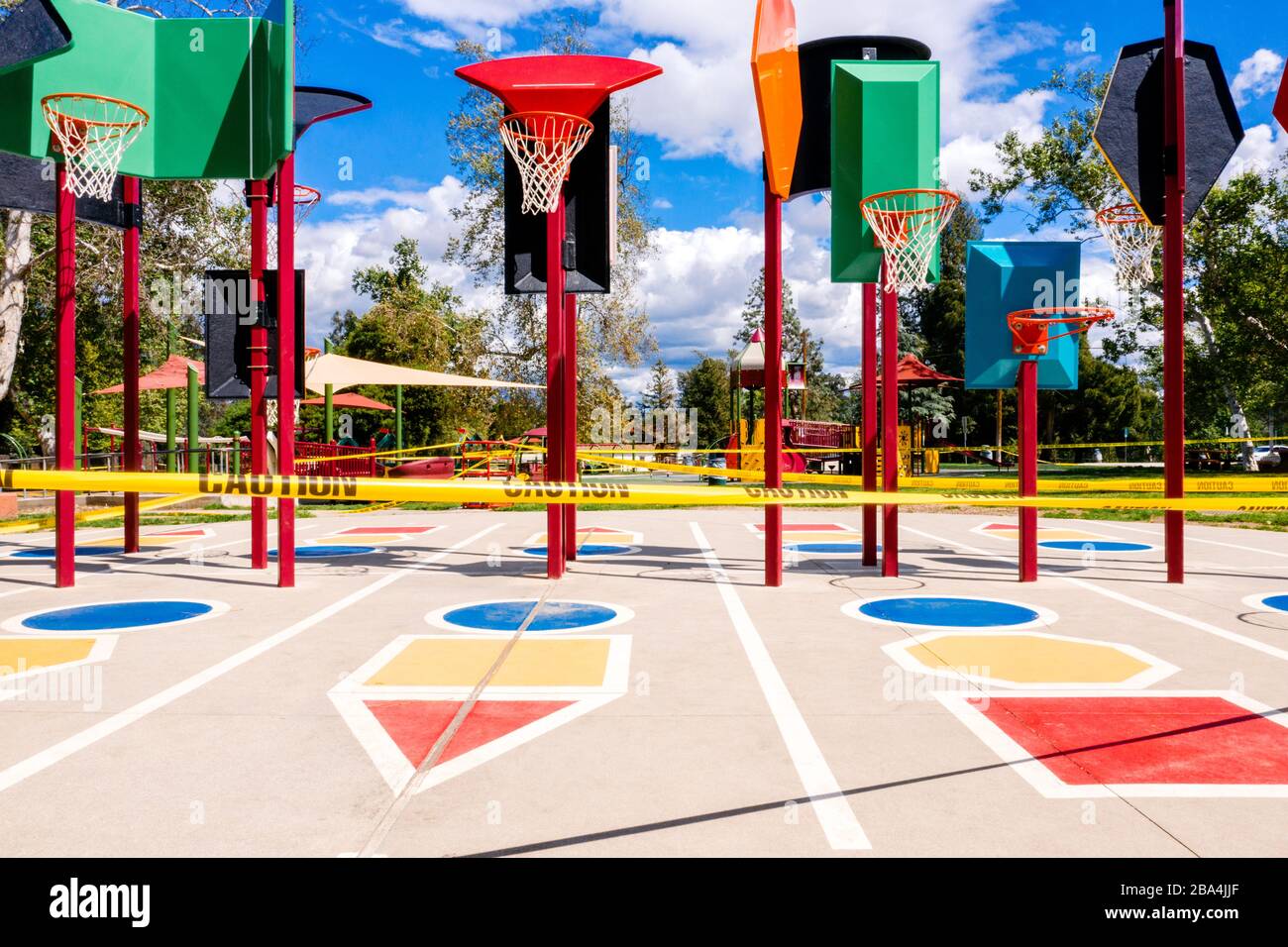 Los Angeles, Kalifornien/USA - Yellow Caution Tape, Minidspielplatz und Basketballnetze dahinter. Minicind-Spielplatz schließt auf COVID-19 Quarantäne in CA. Stockfoto