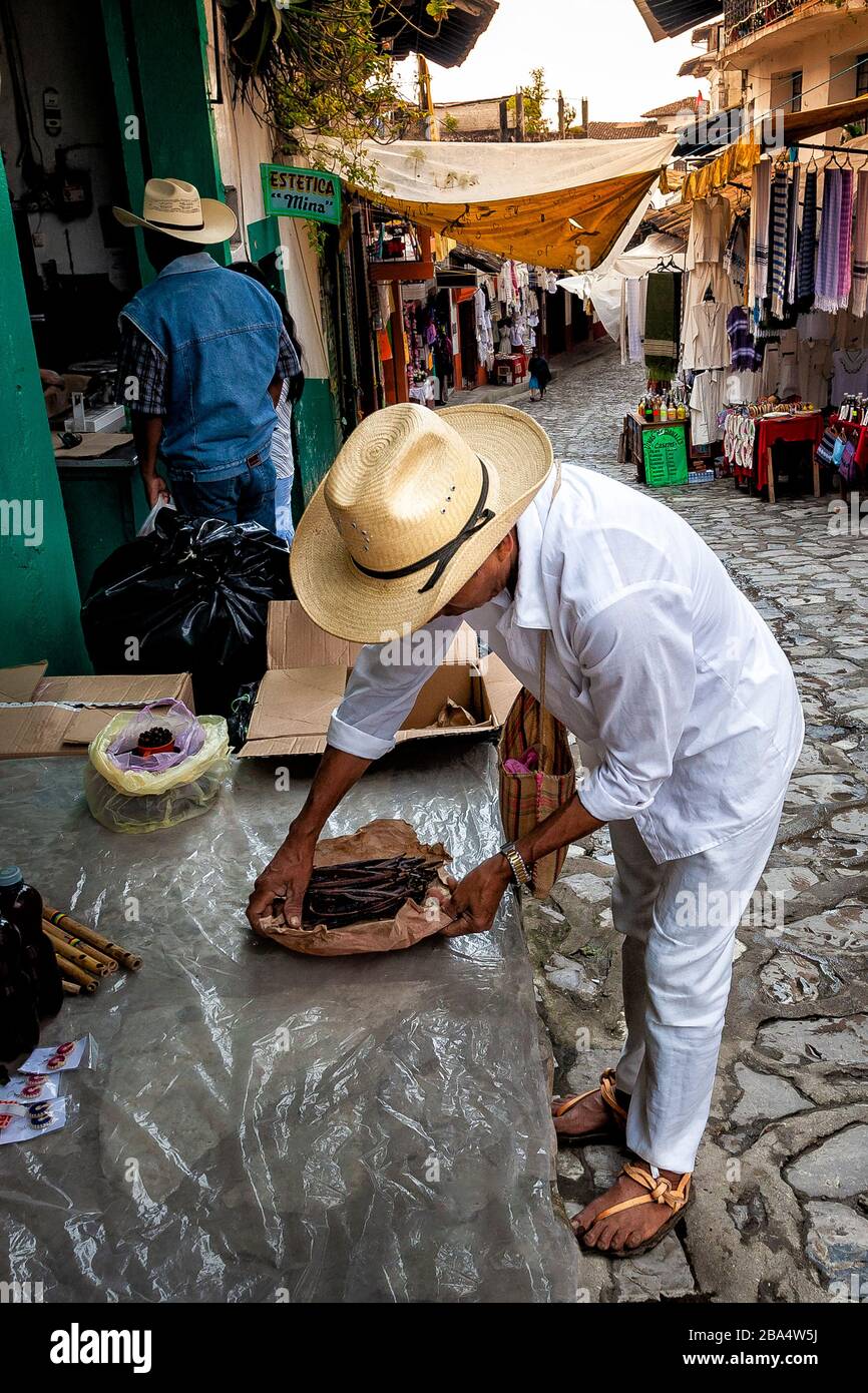 Ein Händler legt Vanillebohnen für den Verkauf auf einem Straßenmarkt in Cuetzalan, Puebla, Mexiko aus. Stockfoto