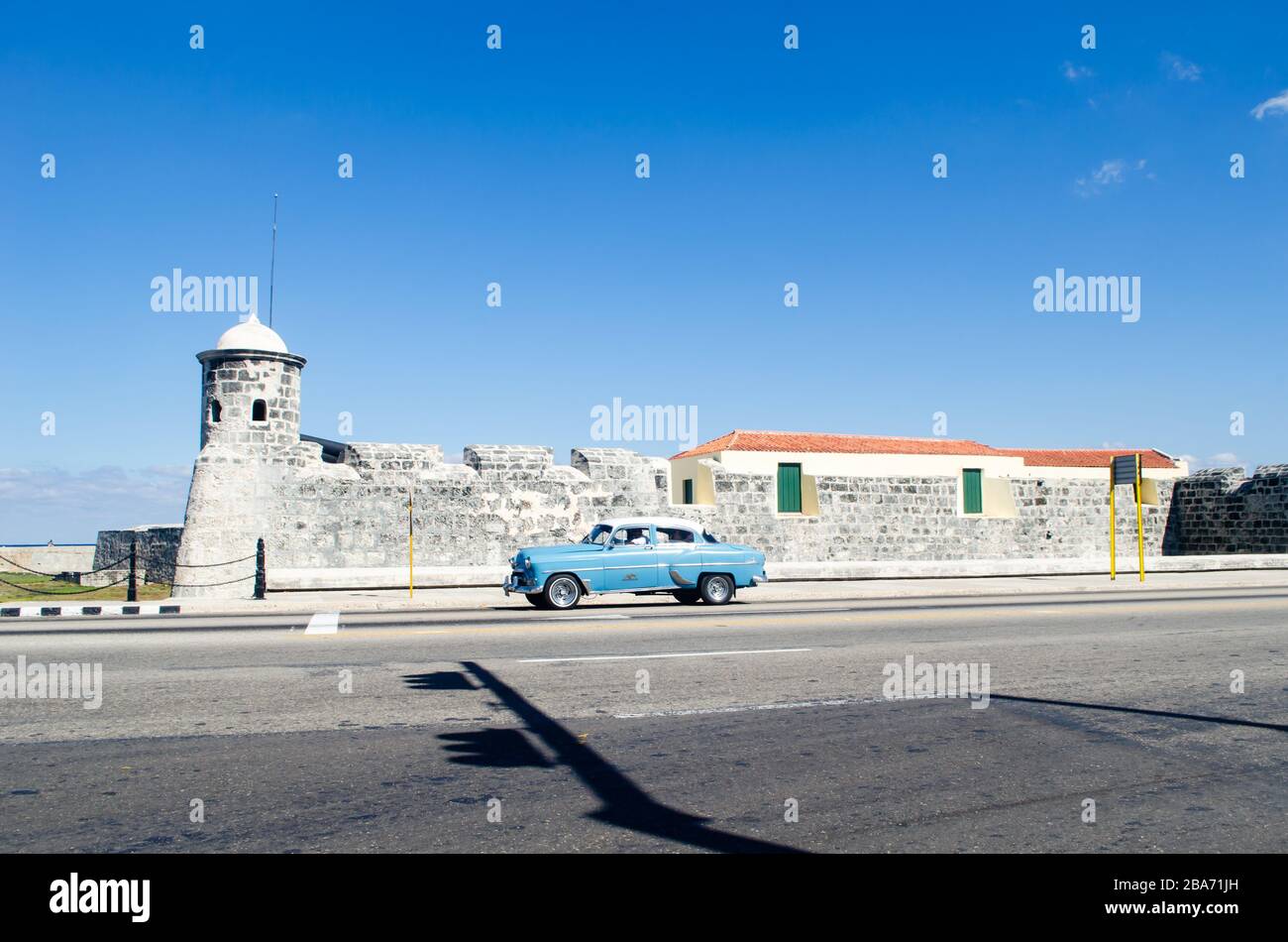Blick auf die Landschaft der Festung Salvador de la Punta. Ein blauer Oldtimer fährt auf der Straße Stockfoto Blick auf die Landschaft der Festung Salvador de la Punta. Ein blauer Oldtimer fährt auf der Straße Stockfoto