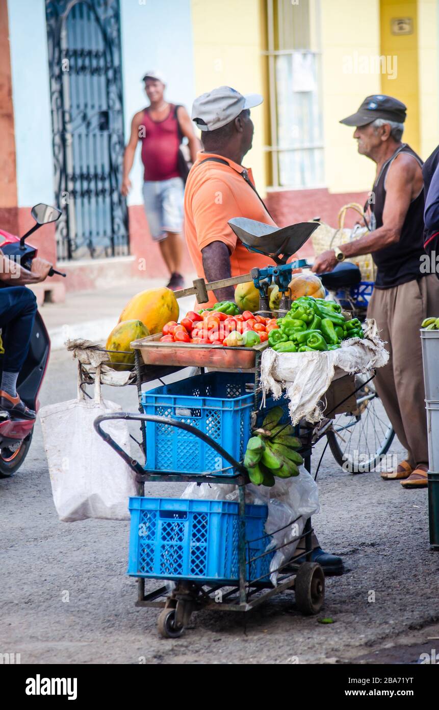 Szene des täglichen Lebens in den Straßen von Trinidad. Ein Gemüse- und Obsthändler wartet auf Käufer Stockfoto