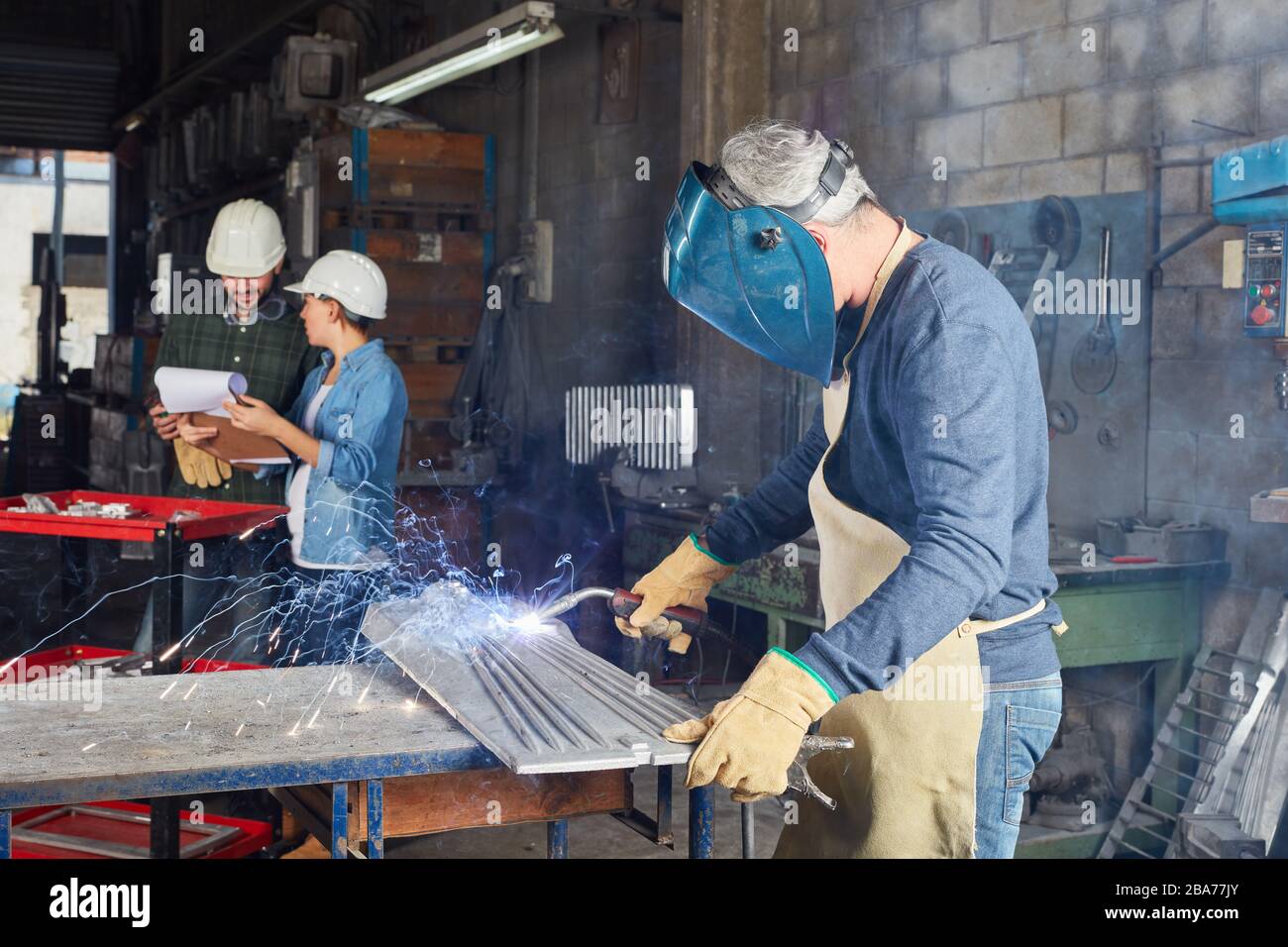 Schweißer als Arbeiter, der Stahl in einer Metallfabrik schweißt Stockfoto
