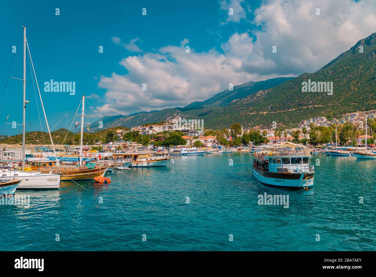 Leuchtturm an einem sonnigen Morgen mit Fischerbooten am Hafen von Kas Türkei Stockfoto