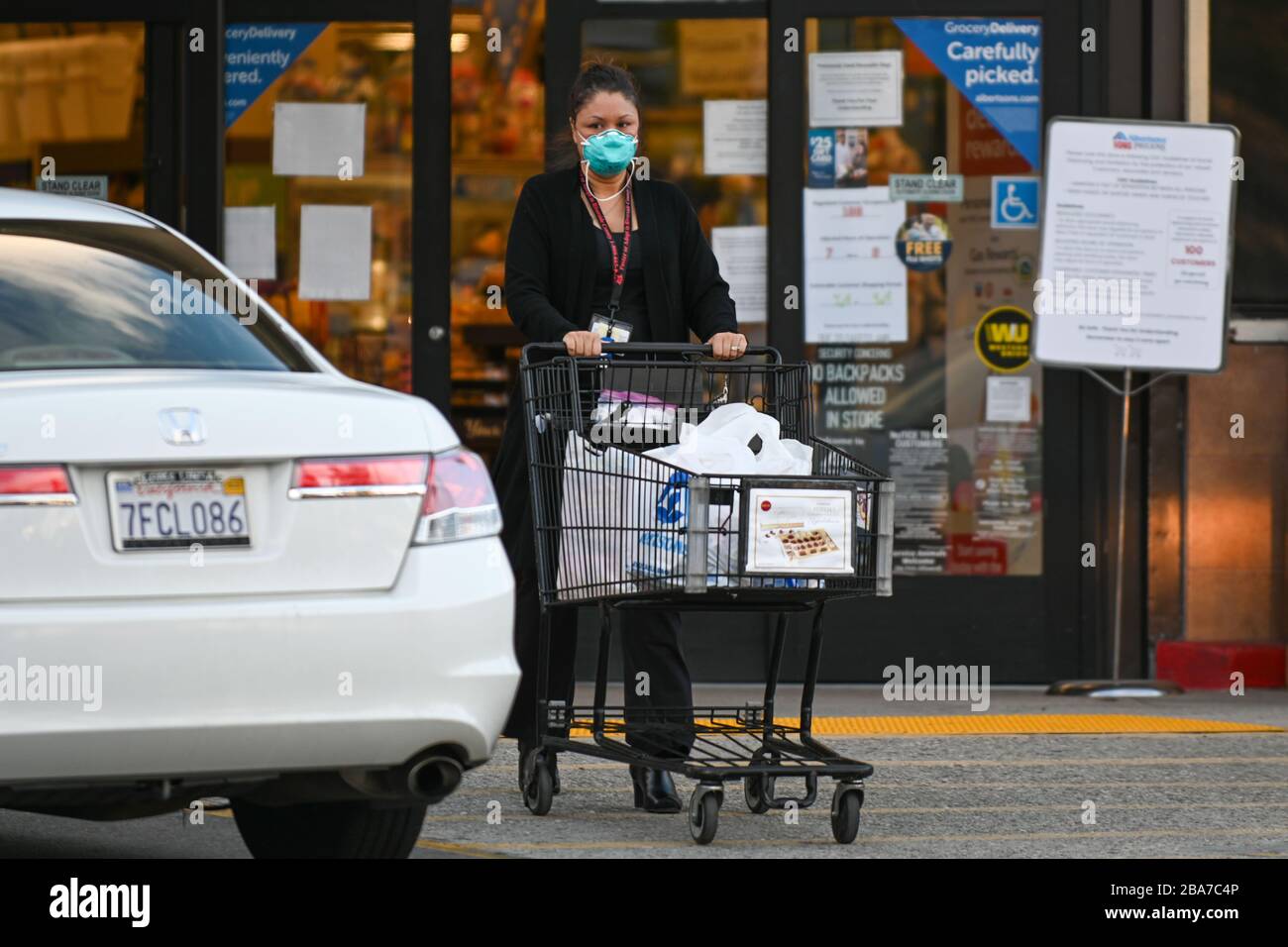 Eine Frau verlässt ein Lebensmittelgeschäft Albertsons, während sie am Mittwoch, 25. März 2020, in Riverside, Kalifornien, eine Maske trägt. Die Lebensmittelhandelskette gab am Montag bekannt, dass sie mehr Menschen einstellen und die Bezahlung erhöhen, um den Bedürfnissen während der neuartigen Coronavirus Pandemie zu helfen. (Dylan Stewart/Bild des Sports) (Foto von IOS/Espa-Images) Stockfoto