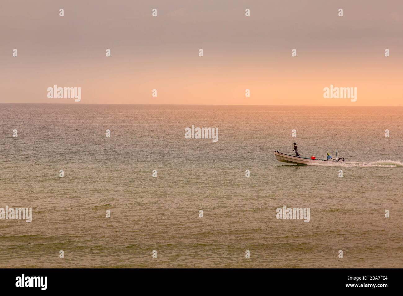 Ein Fischerboot fährt über die Küstengewässer des Golf von Oman im Oman im Nahen Osten. Stockfoto