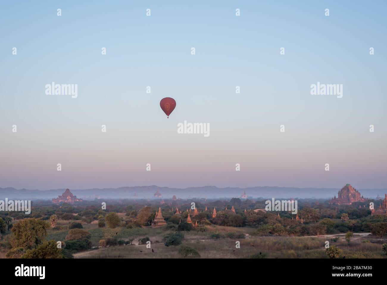 Bei Sonnenaufgang fliegen Luftballons über Tempel in Bagan, Myanmar Stockfoto