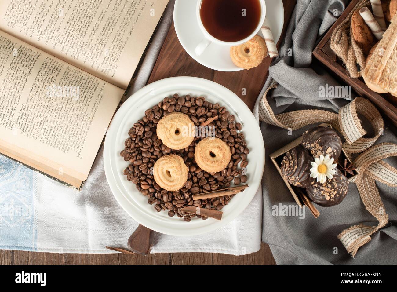 Kaffeebohnen, Plätzchen, Pralinen und eine Tasse Tee Stockfoto