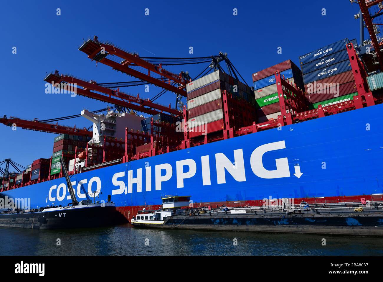 Rotterdam, die Niederlande-August 2019; Tiefwinkelansicht des Mittelschiffabschnitts des Containerschiffs, "von Land zu Land" im Terminal mit Portalkränen risin Stockfoto