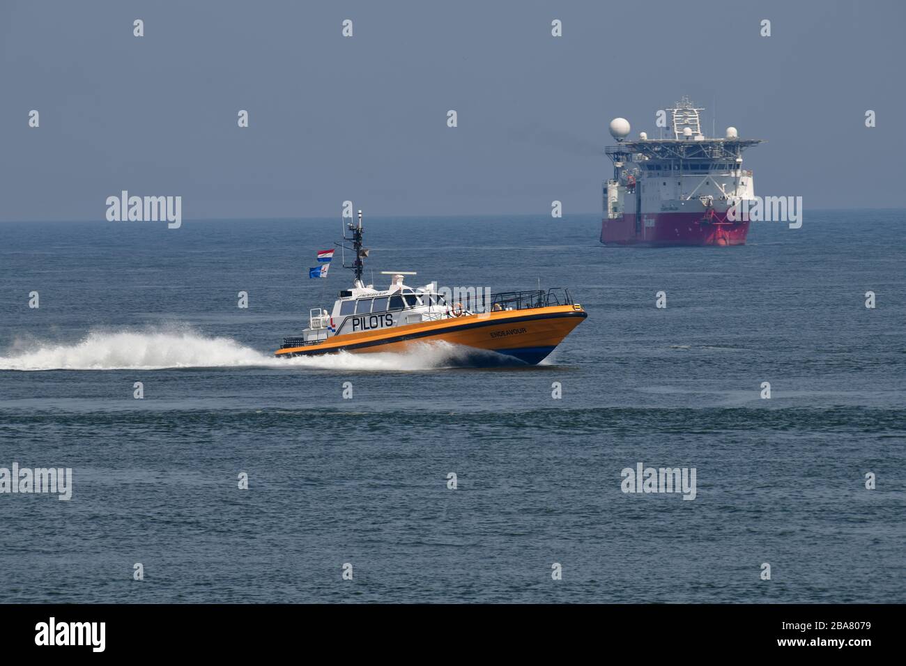 Lotsenboot mit hoher Geschwindigkeit am Eingang des Rotterdamer Hafenboots mit im Hintergrund rot-weiß abgefärbt Stockfoto