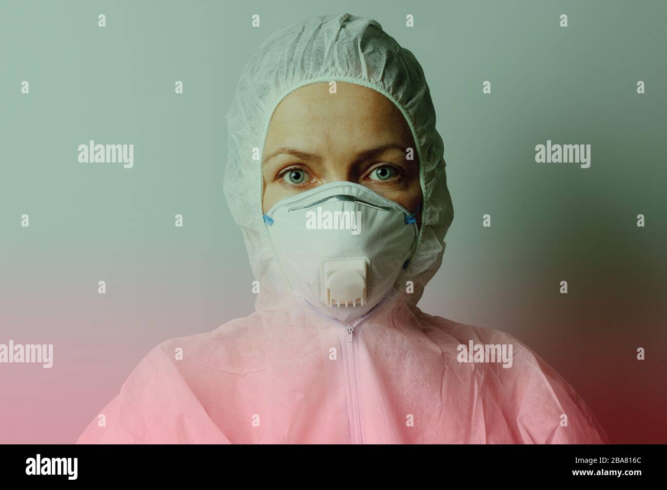 Frau in Maske und Schutzanzug, grün und rot getönt, Nahaufnahme. Stockfoto
