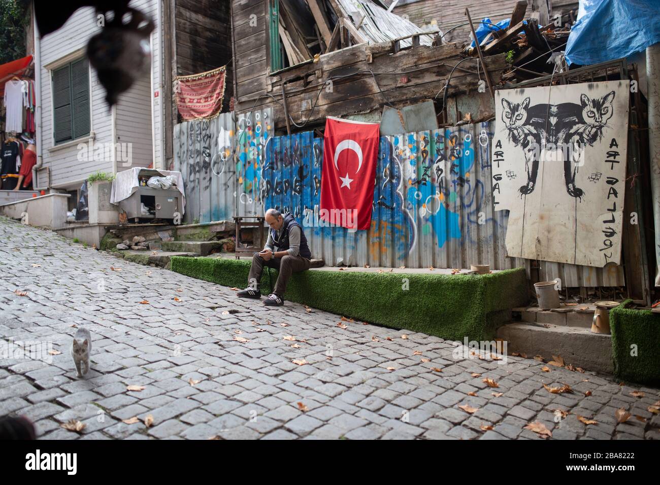 Der ältere Maler sitzt außerhalb seines Kunststudios in einem historischen Teil von Istanbul Stockfoto