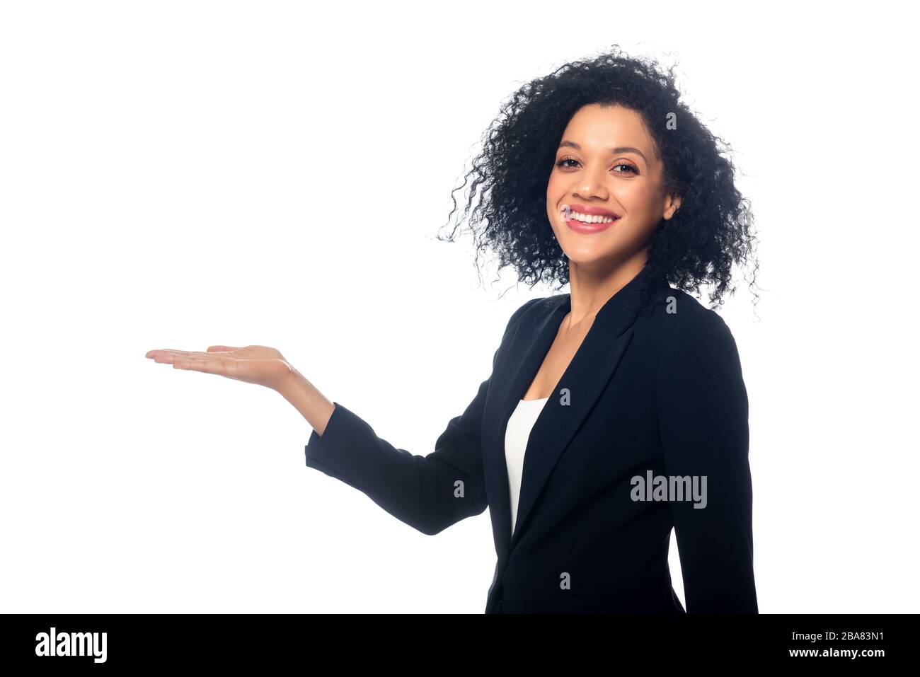Schöne afroamerikanische Frau zeigt mit der Hand, schaut auf die Kamera und lächelt isoliert auf Weiß Stockfoto