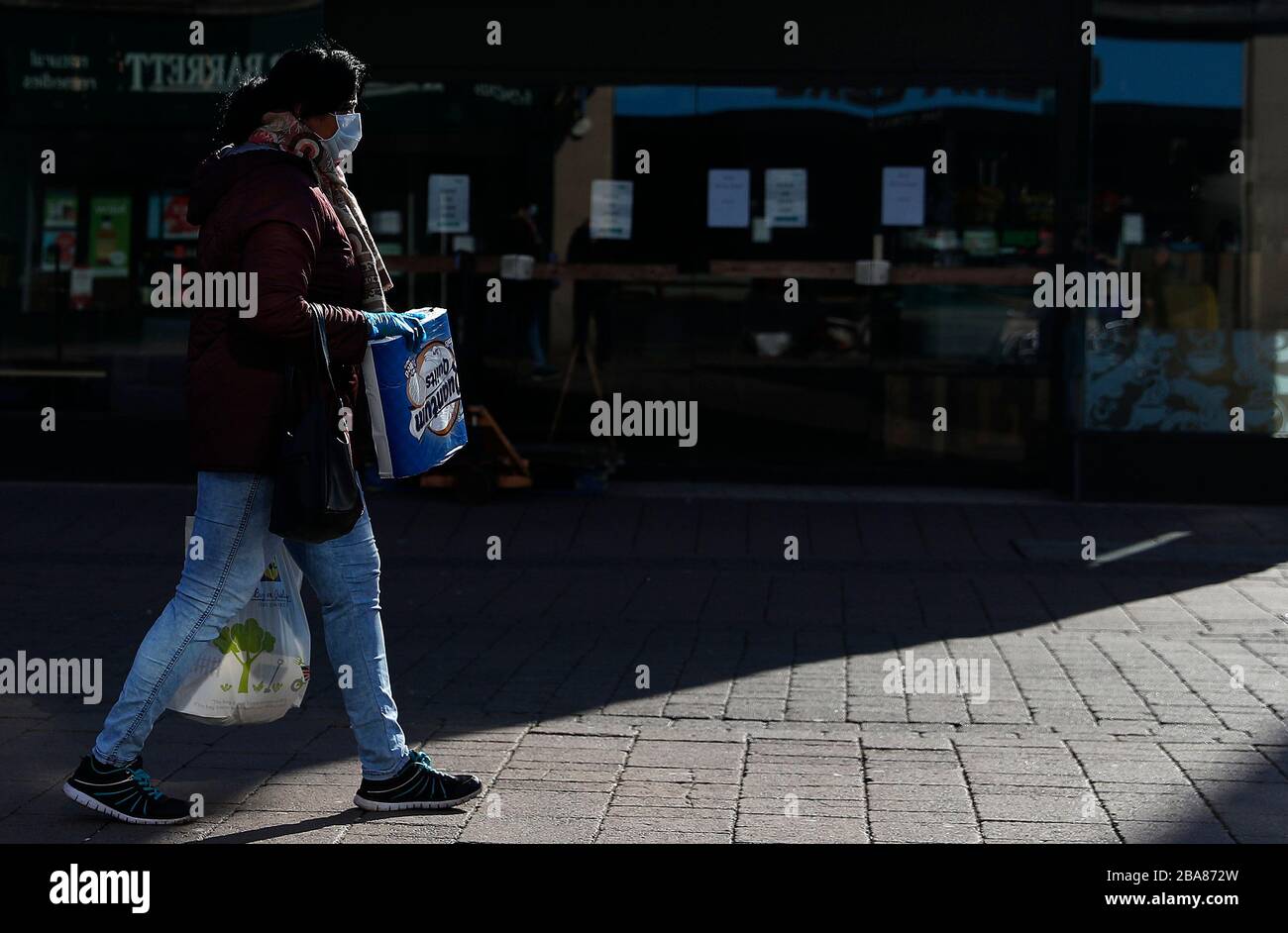 Loughborough, Leicestershire, Großbritannien. März 2020. Covid 19. Eine maskierte Frau führt während der Coronavirus Pandemie Toilettenpapier durch den Straßenmarkt in Loughborough. Credit Darren Staples/Alamy Live News. Stockfoto