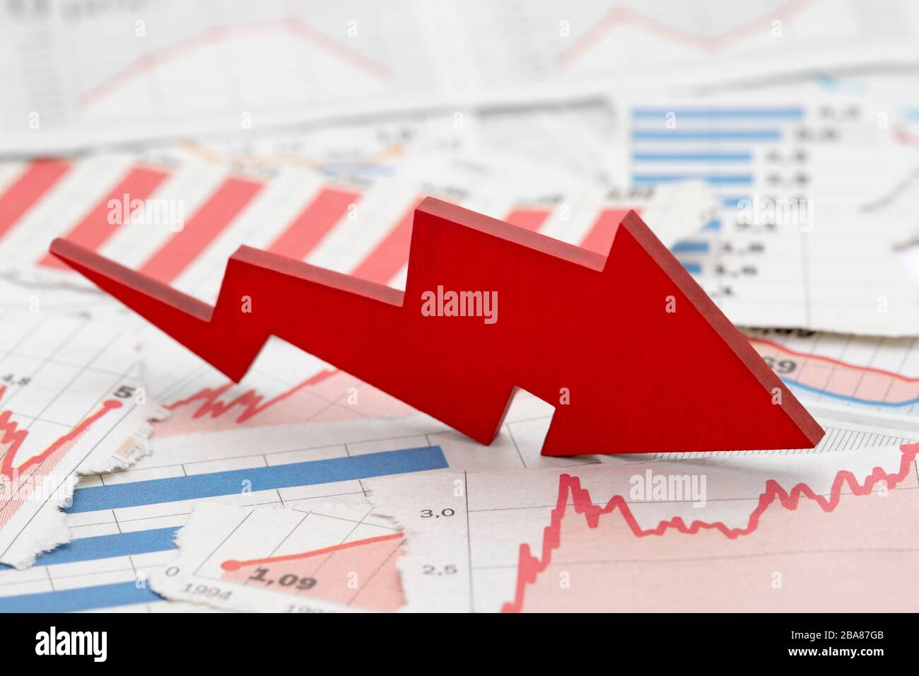 Finanzkrisenkonzept mit fallendem roten Pfeil in den Finanzcharts von Zeitungen Stockfoto