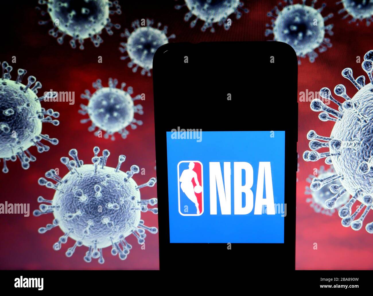 In dieser Abbildung wird ein Logo der National Basketball Association (NBA) auf einem Smartphone mit einem Computermodell des Coronavirus COVID-19 im Hintergrund angezeigt. Stockfoto
