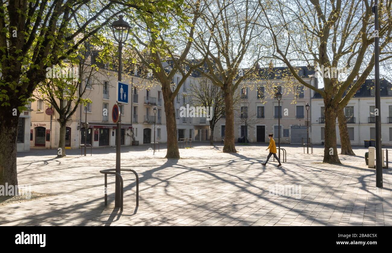 Leere plaza, Mädchen mit Maske inmitten von COVID-19 in Frankreich Stockfoto