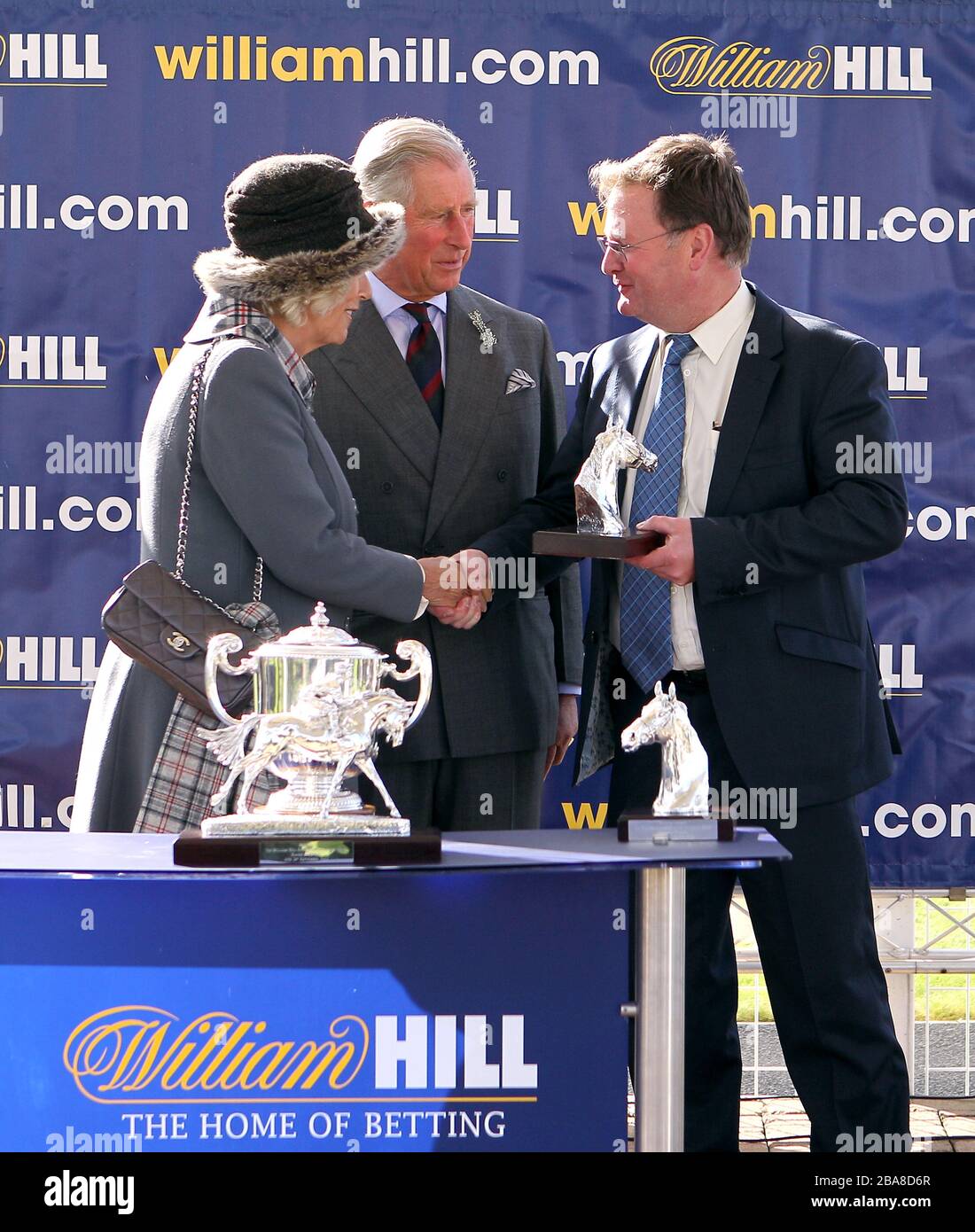 Trainer Michael Dods erhält vom Prince of Wales und der Duchess of Cornwall eine Trophäe, nachdem Osteopathisches Remedy den William Hill mit Unterstützung von Dumfries House Ayrshire Handicap gewonnen hat Stockfoto